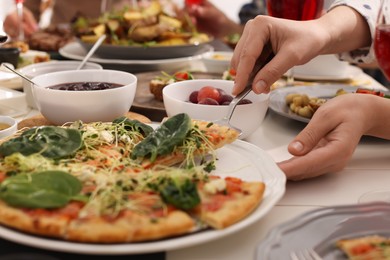 Photo of Woman taking slice of pizza during brunch at table, closeup