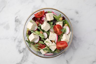 Bowl of tasty salad with tofu and vegetables on white marble table, top view