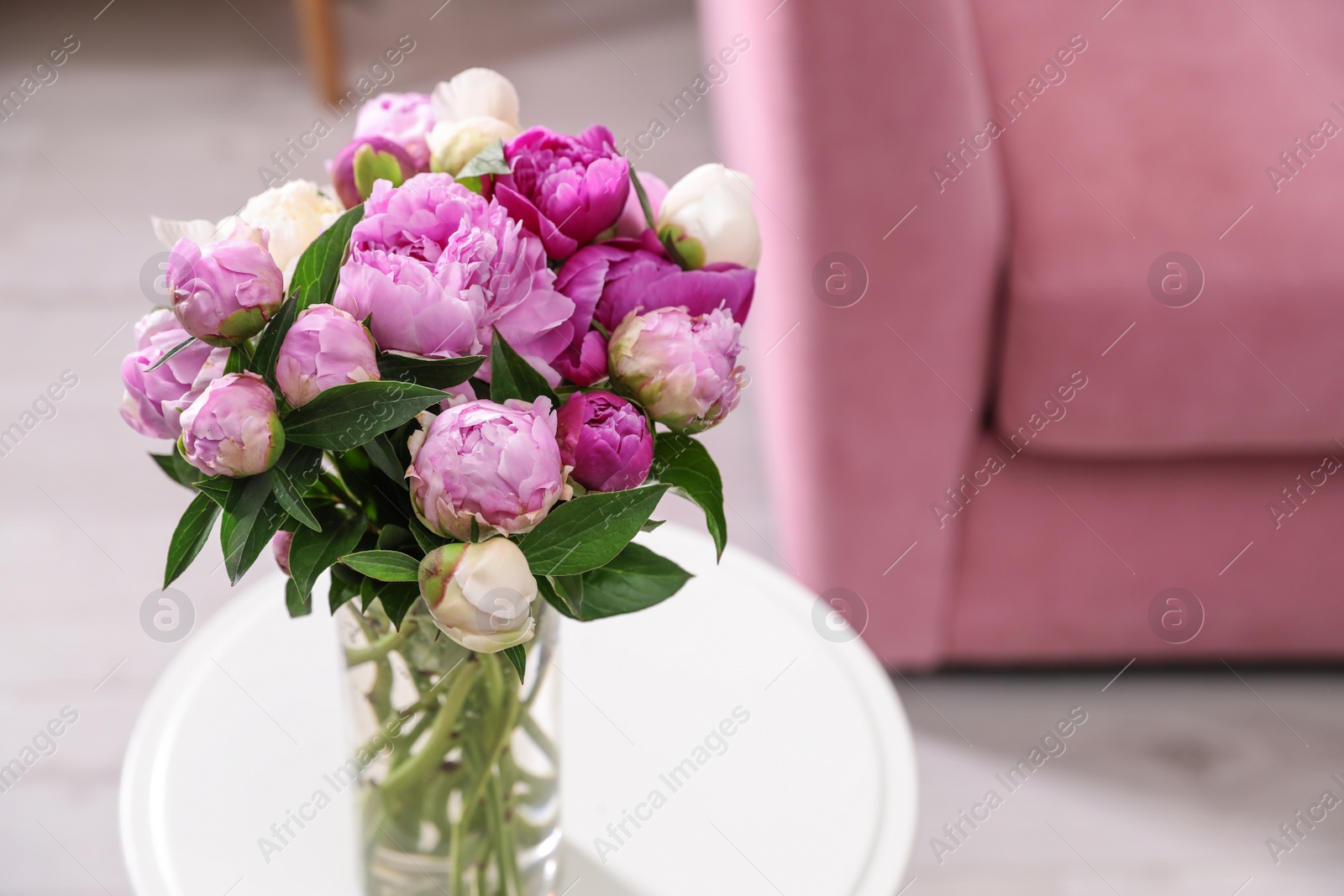 Photo of Bouquet of fresh peonies on table in room, space for text