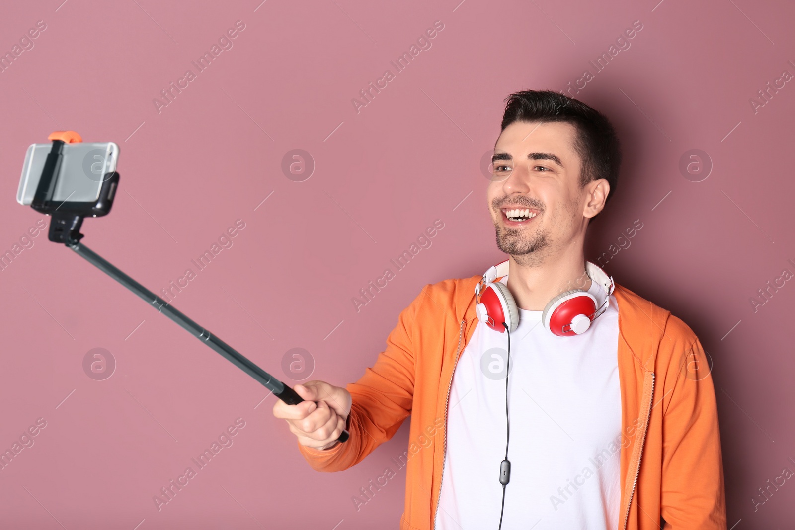 Photo of Handsome man taking selfie against color background