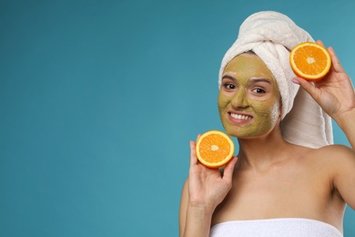 Photo of Beautiful woman with mask on face and cut orange against color background. Space for text