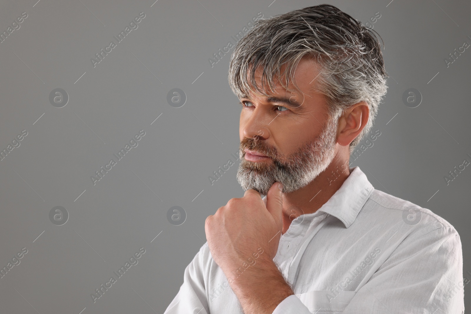 Photo of Portrait of confident man with beautiful hairstyle on light grey background. Space for text