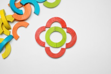 Photo of Colorful wooden pieces of play set on white background, flat lay. Educational toy for motor skills development