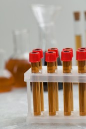 Test tubes with brown liquid in stand on table