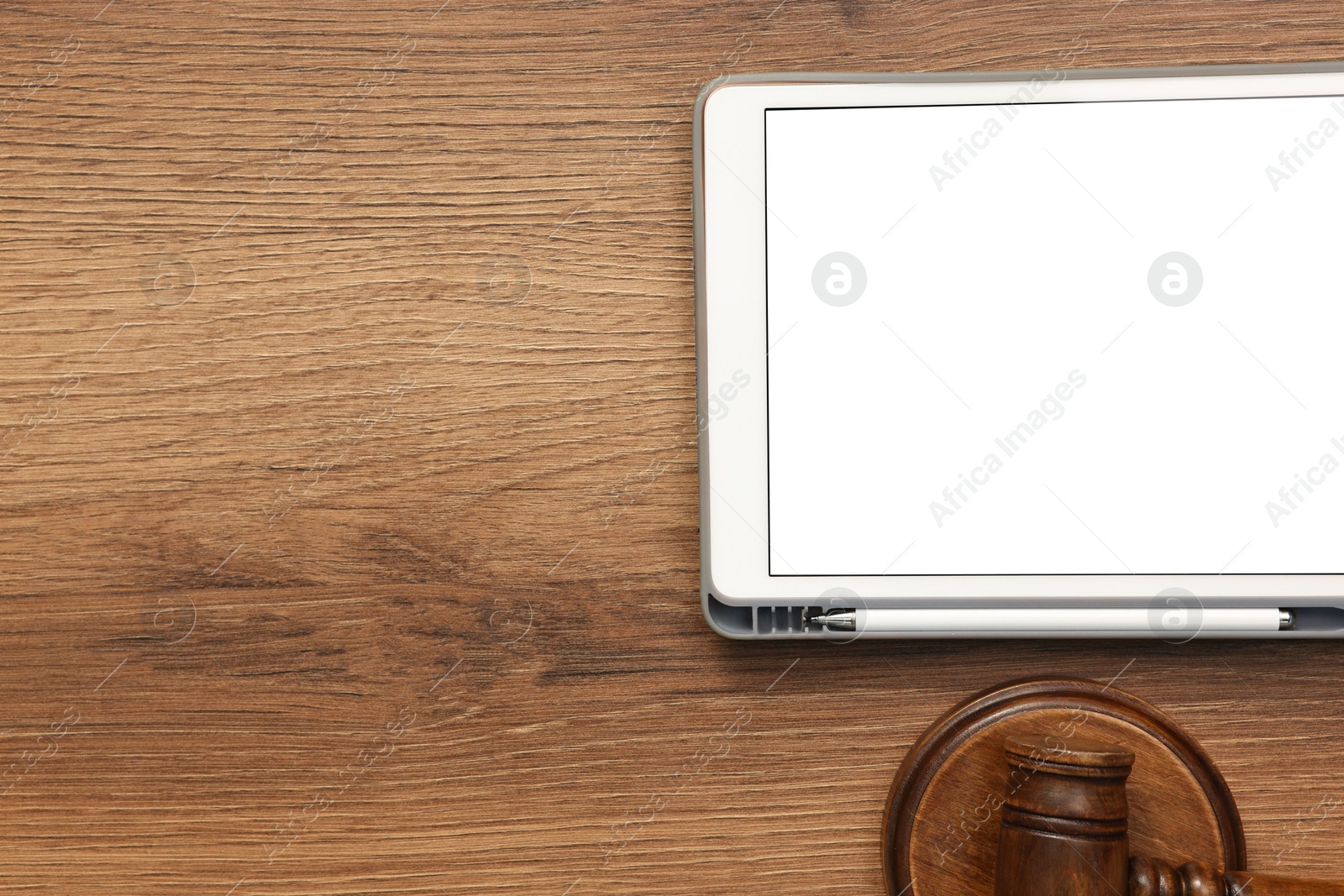Photo of Modern tablet and gavel on wooden table, flat lay. Space for text