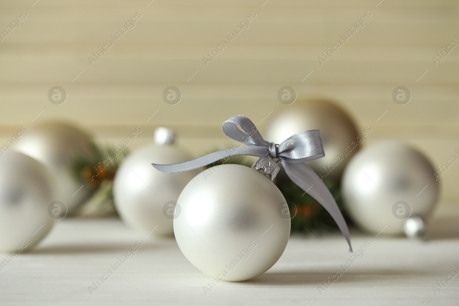 Photo of Beautiful Christmas ball on white table against blurred background. Space for text