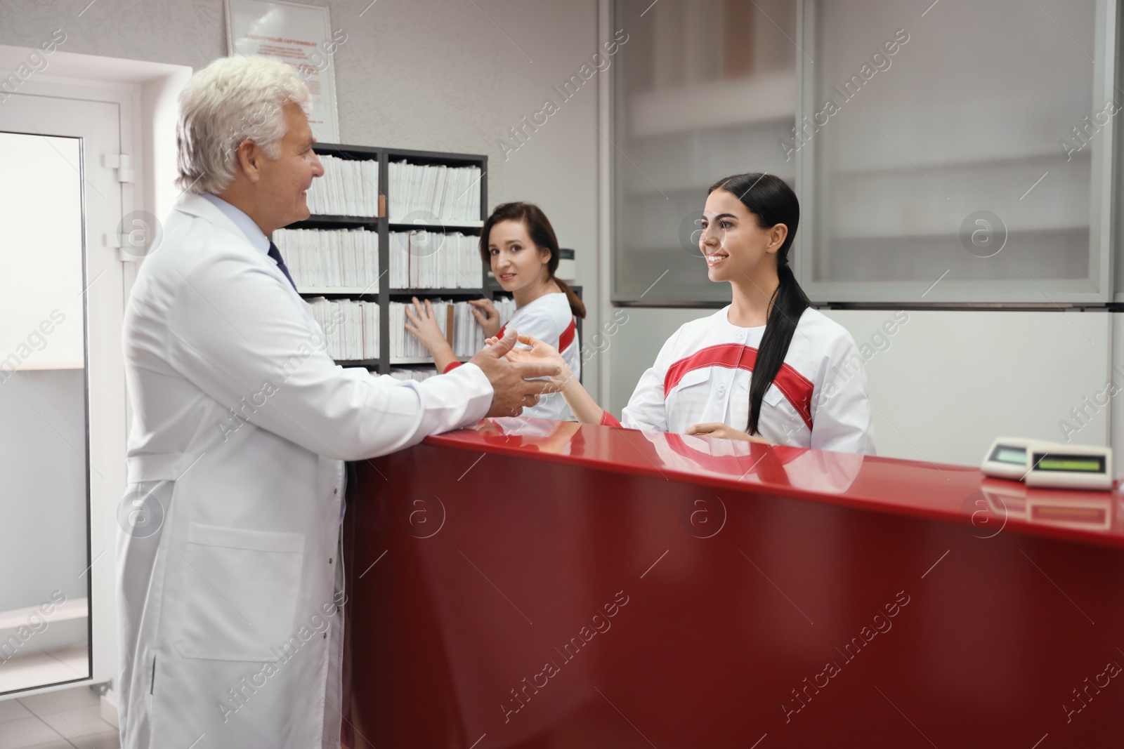 Photo of Reception of modern surgery clinic with working staff