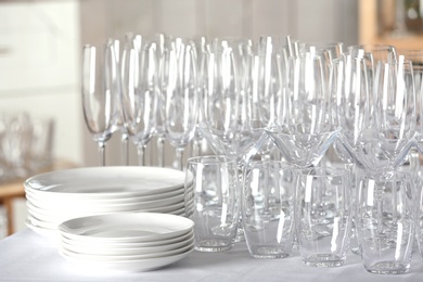 Photo of Set of empty glasses and dishware on table indoors