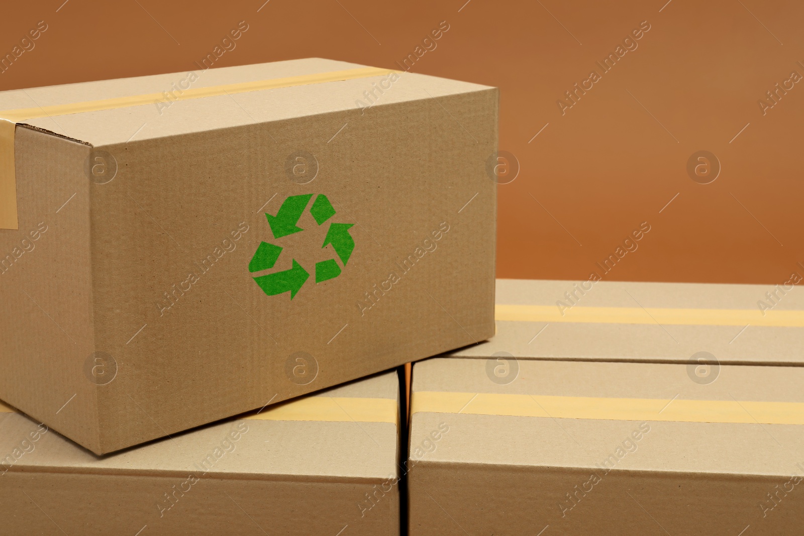 Image of Cardboard box with recycle sign stamp on brown background