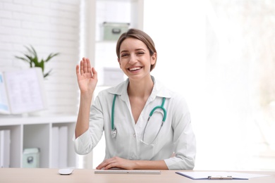 Female doctor using video chat at workplace, view from camera perspective