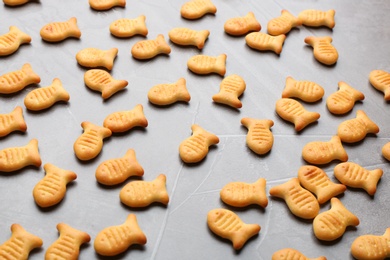 Photo of Delicious crispy goldfish crackers on grey table