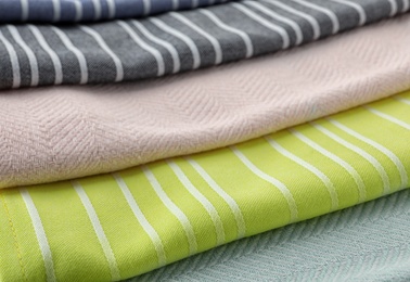 Different folded fabric napkins as background, closeup view