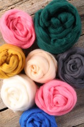 Photo of Colorful felting wool on wooden table, top view