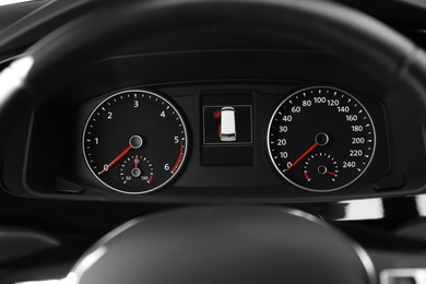 Photo of Modern speedometer, tachometer and open door warning sign on car dashboard