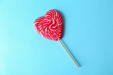 Heart shaped lollipop on color background, top view. Sweet love