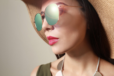 Image of Beautiful woman in stylish sunglasses and hat on beige background