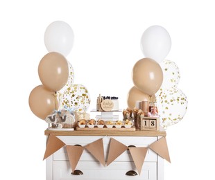 Photo of Baby shower party. Different delicious treats on chest of drawers and decor against white background