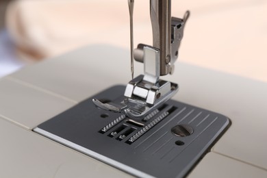 White sewing machine on light background, closeup