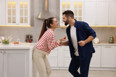 Happy lovely couple dancing together in kitchen