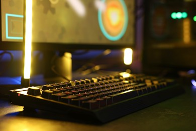 Photo of Playing video games. Computer keyboard on table, closeup