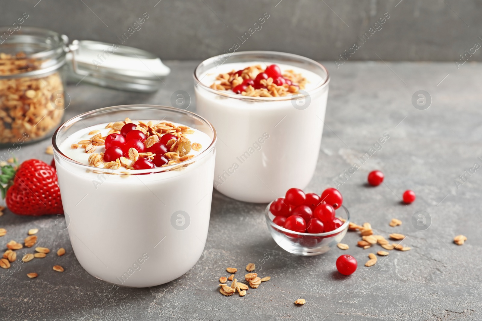 Photo of Glasses with yogurt, berries and granola on table