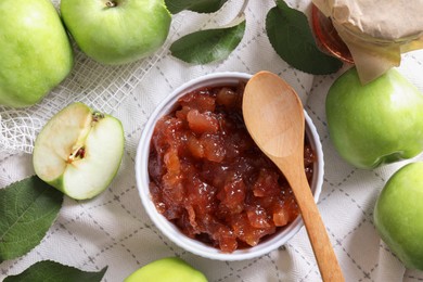 Photo of Bowl of delicious apple jam and fresh fruits on white tablecloth, flat lay