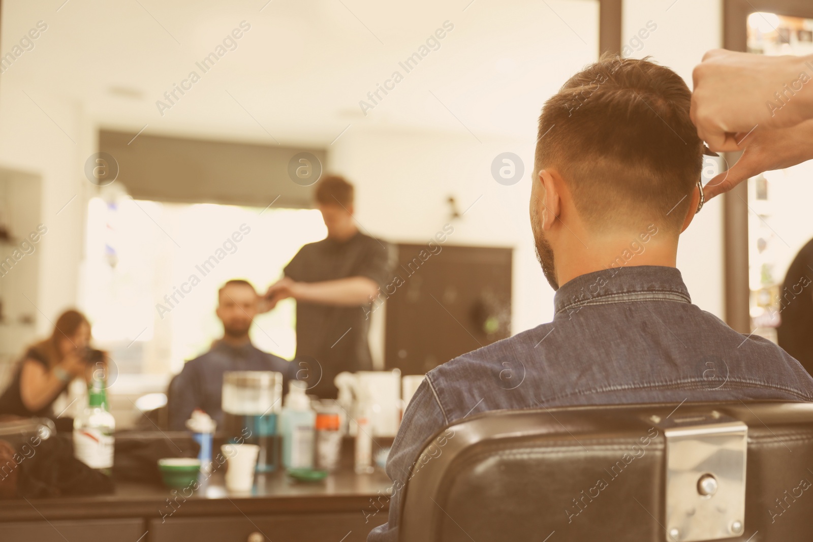 Photo of Professional barber working with client in hairdressing salon. Hipster fashion