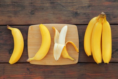 Delicious bananas on wooden table, flat lay