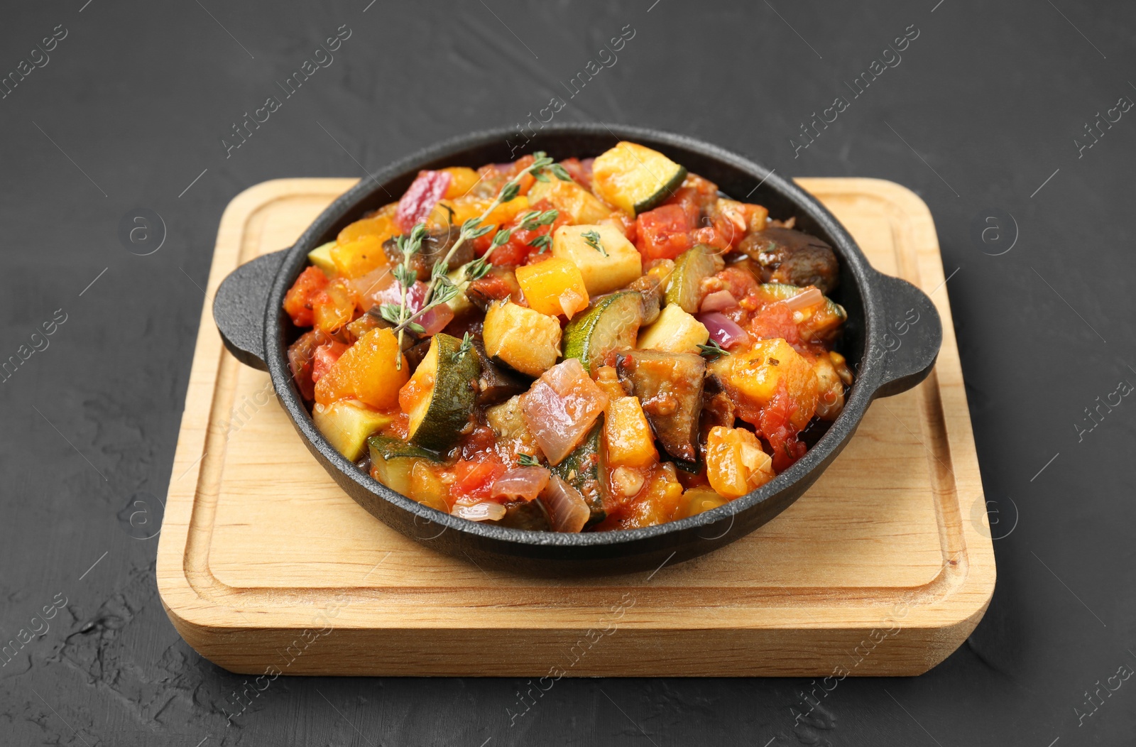 Photo of Dish with tasty ratatouille on black table
