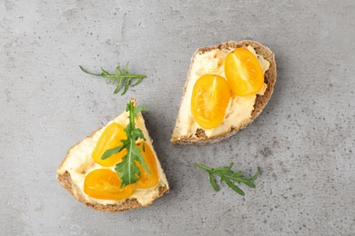 Tasty fresh tomato bruschettas on grey table, flat lay