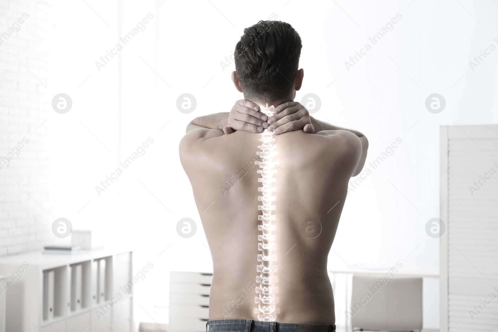 Image of Man suffering from pain in spine in orthopedist's office. Black and white effect