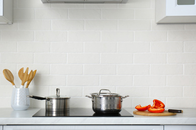 Photo of Kitchen counter with utensils and cookware on stove