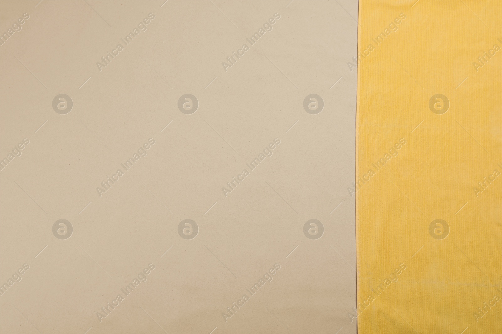 Photo of Yellow beach towel on sand, top view. Space for text