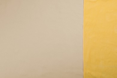 Yellow beach towel on sand, top view. Space for text