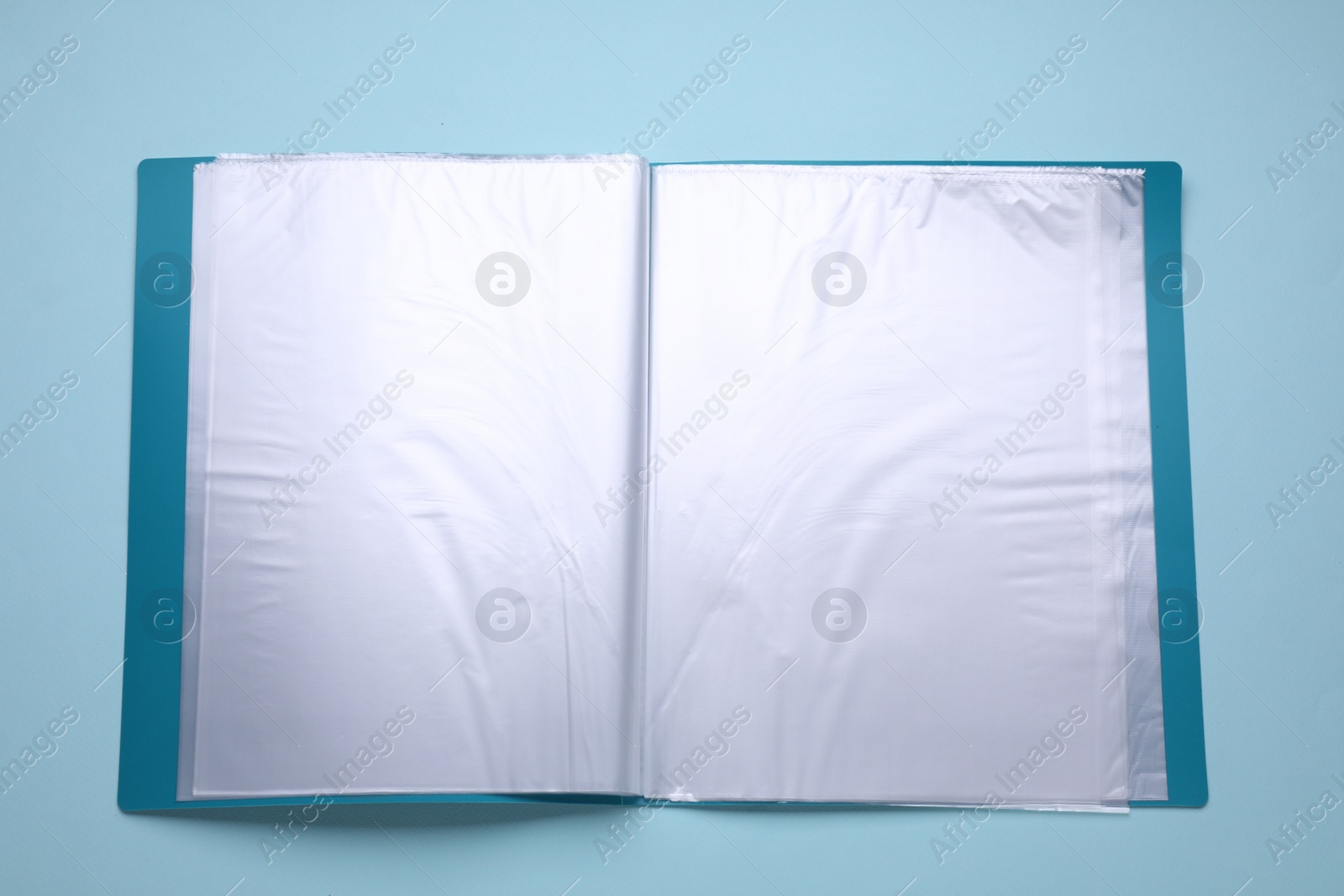 Photo of File folder with punched pockets and paper sheets on turquoise background, top view