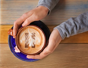 Image of Coffee Break. Woman with cup of cappuccino at wooden table, top view