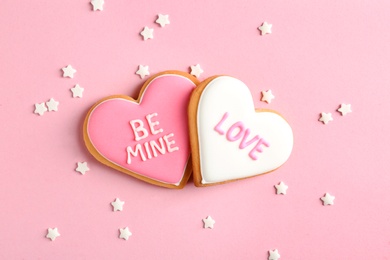 Photo of Composition with decorated heart shaped cookies on color background, top view. Valentine's day treat