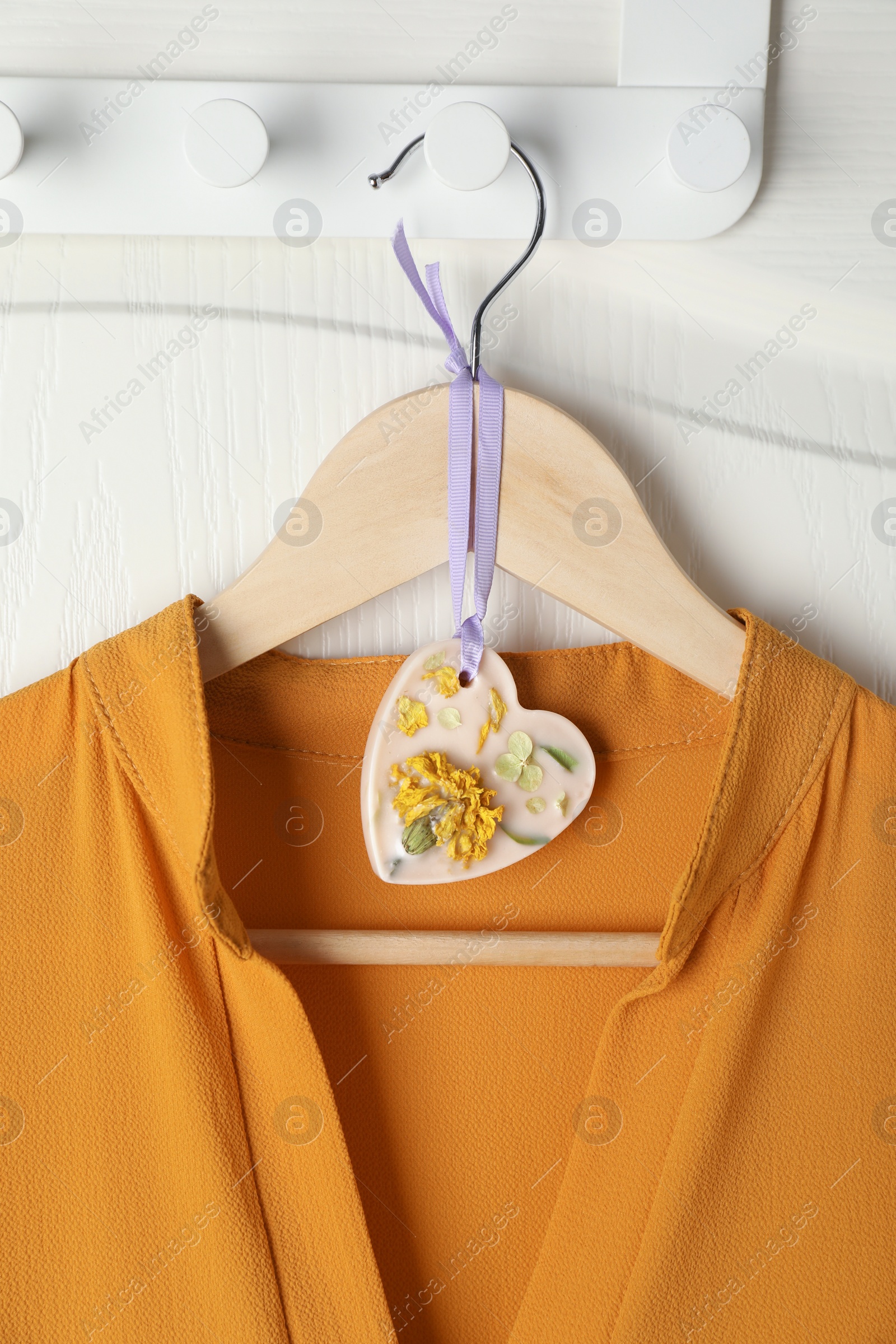 Photo of Scented sachet with flowers and stylish clothes on hanger