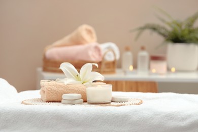 Photo of Beautiful spa composition with burning candle and stones on massage table in wellness center. Space for text