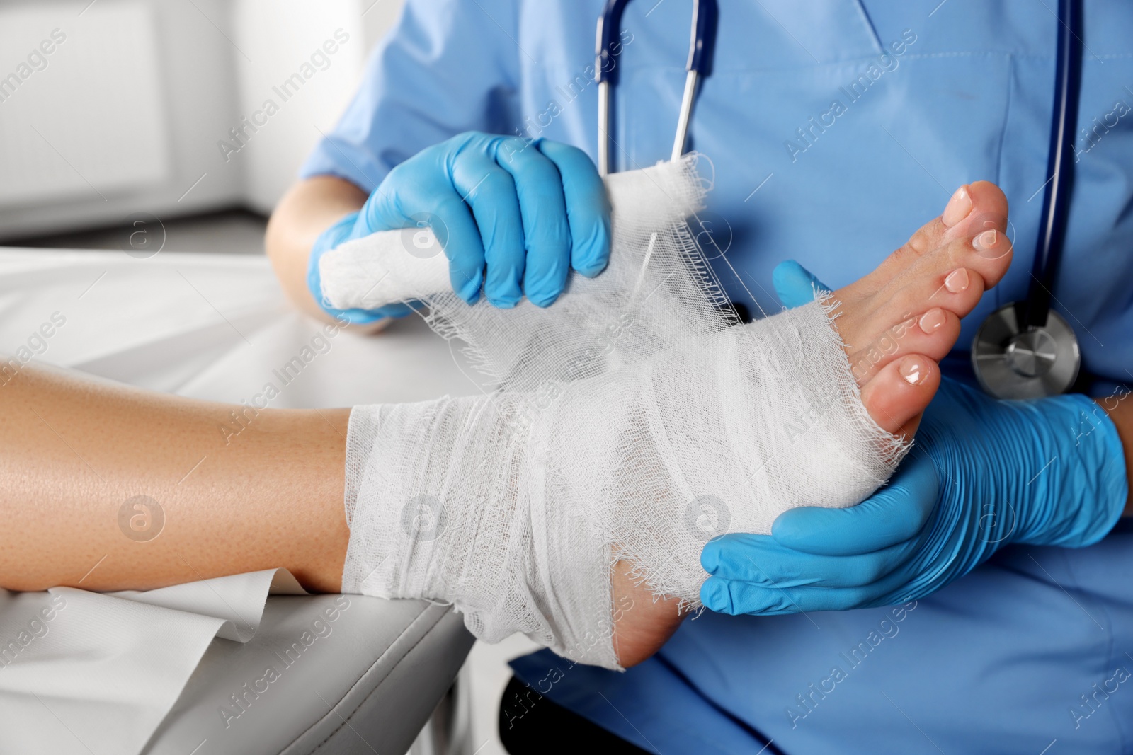 Photo of Doctor applying bandage onto patient's foot in hospital, closeup