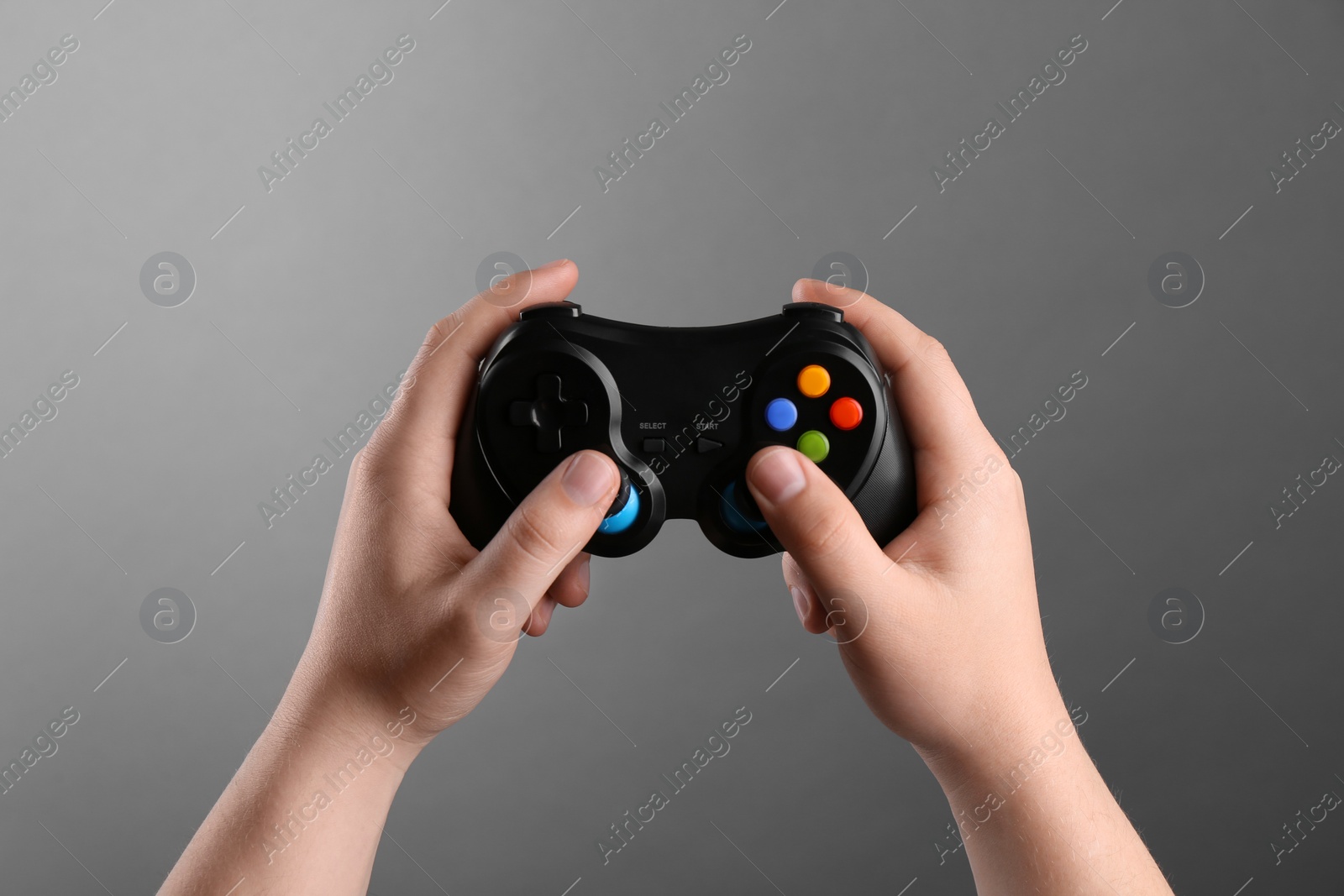 Photo of Woman using wireless game controller on grey background, closeup