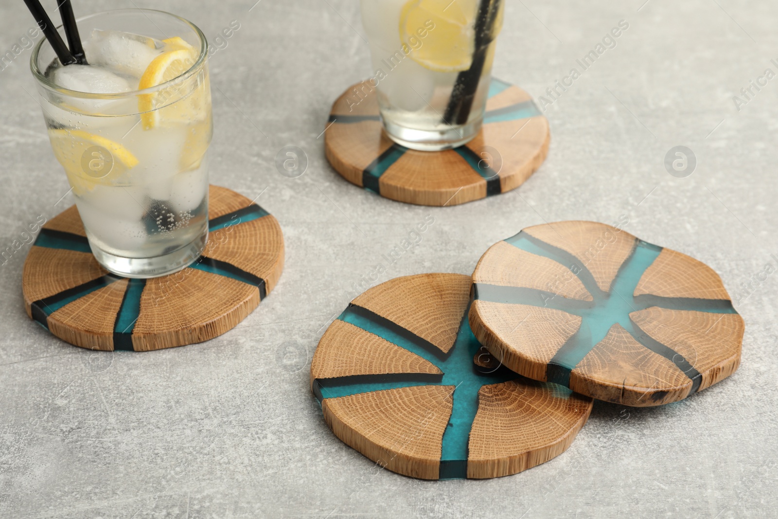Photo of Cocktail and stylish cup wooden coasters on light grey table