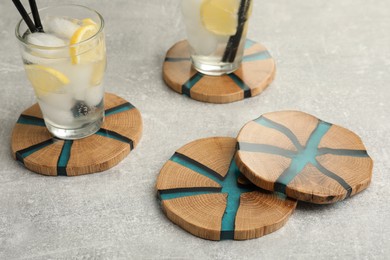 Cocktail and stylish cup wooden coasters on light grey table