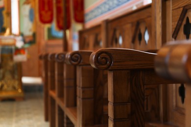 Photo of Empty wooden bench in church, closeup. Space for text