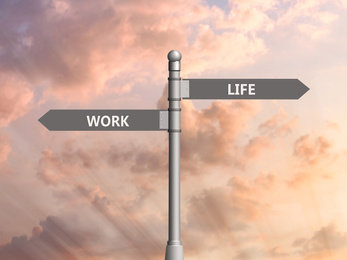 Image of Signpost against beautiful summer sky. Concept of balance between work and life