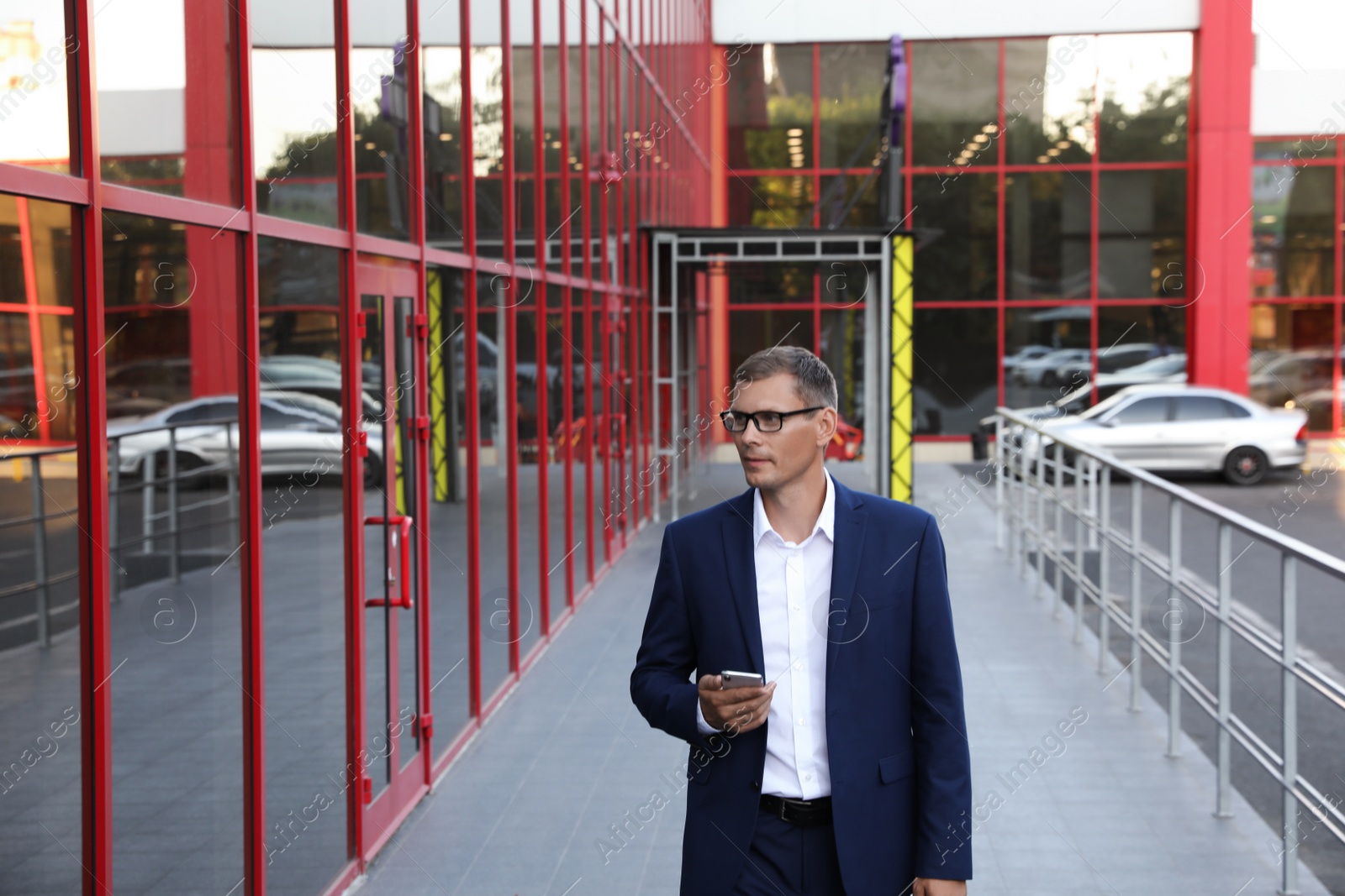 Photo of Businessman with modern smartphone on city street