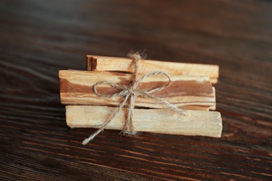 Tied palo santo sticks on wooden table, top view