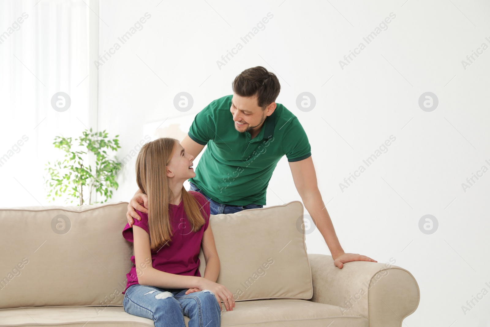 Photo of Father talking with his teenager daughter at home