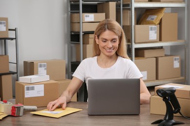 Seller with parcels and laptop in office. Online store