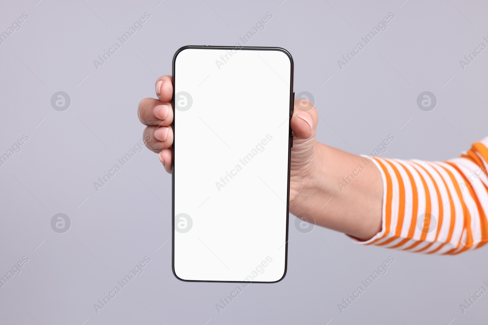 Photo of Woman holding smartphone with blank screen on light grey background, closeup. Space for text